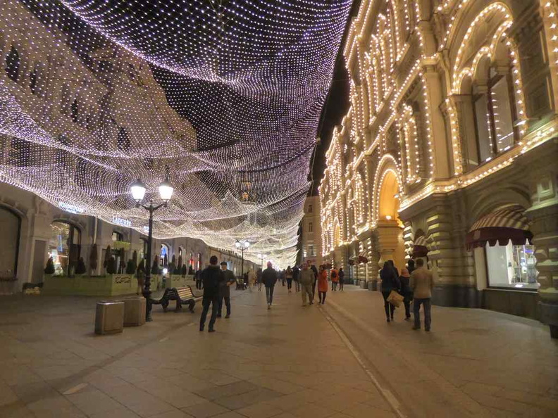 Lights along Nikolskaya street with the lighted GUM  west-facing shop front.