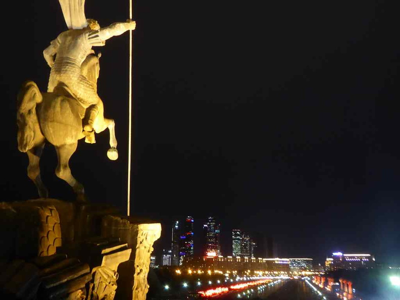 St George statue overlooking the pathway leading to the monument with the city of Moscow lit in the night