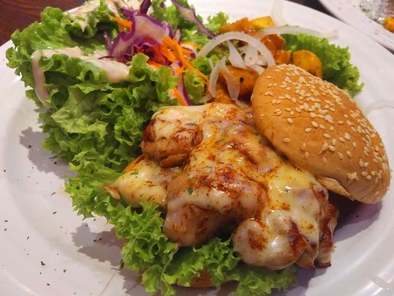 Cheesey chicken burger, it is essential their chicken between burger buns, topped with generous serving of greens.