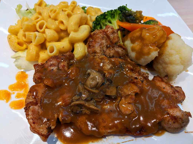 Chefs place western safra Mushroom grilled Chicken breast with mac and choose and vegetables