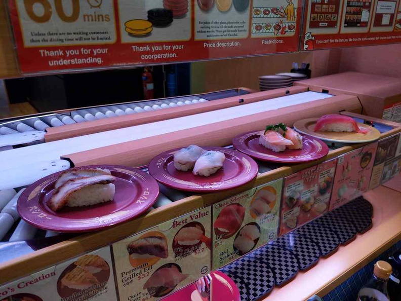 You can use the tablet on your table to order specific items, made to order. They are delivered to you on a top rail above the conveyor belt to your seat