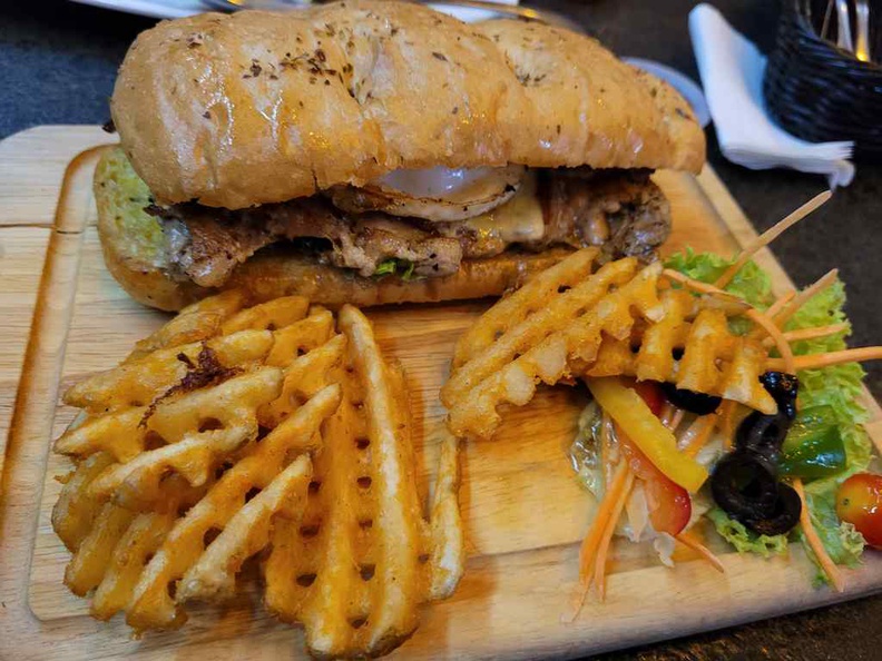 Chicken burger is essentially a chicken chop patty tucked between sandwich buns, served with waffle fries and salad