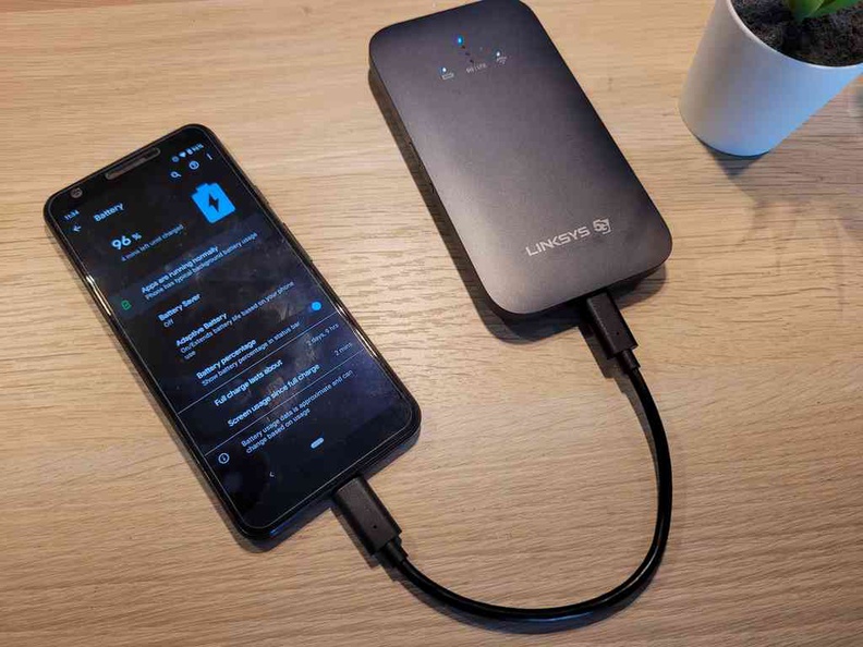 The Linksys 5G router charging a smaller Google Pixel 3 phone, albeit slowly