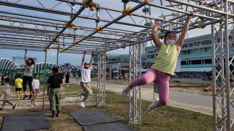 Kids and kids-at-heart doing the monkey bars at the Solder strong outdoor area course