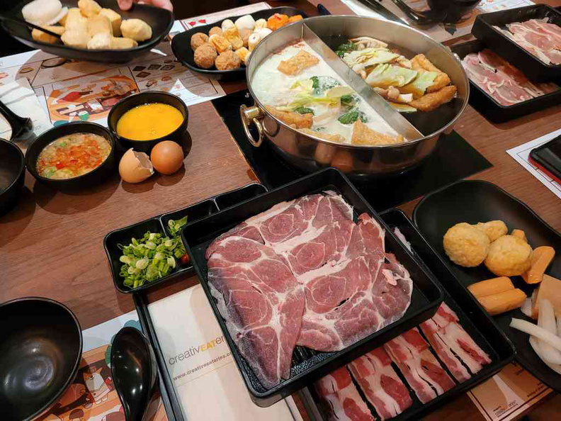 A table loaded with serving plates at typical sight here at Suki-ya