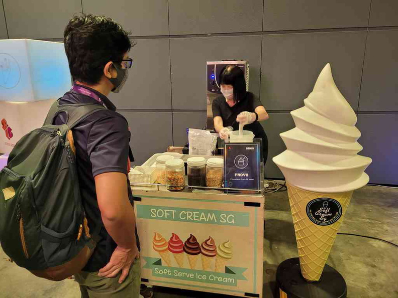 Ice cream booth at the lightning talk hall with a small cafe like area with standing tables with coffee for attendees