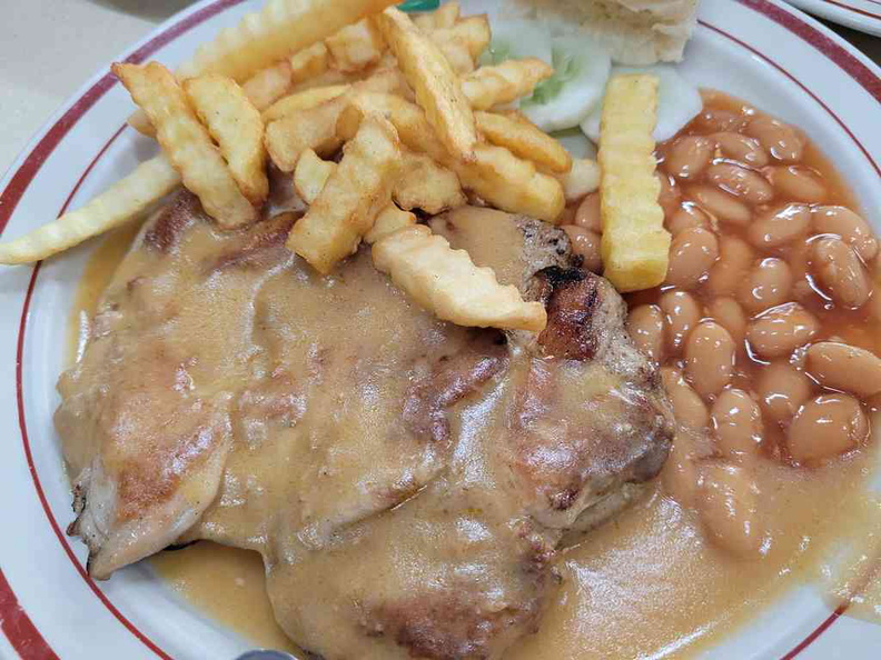 Staple chicken chop served with fries, cucumber slices and baked beans.