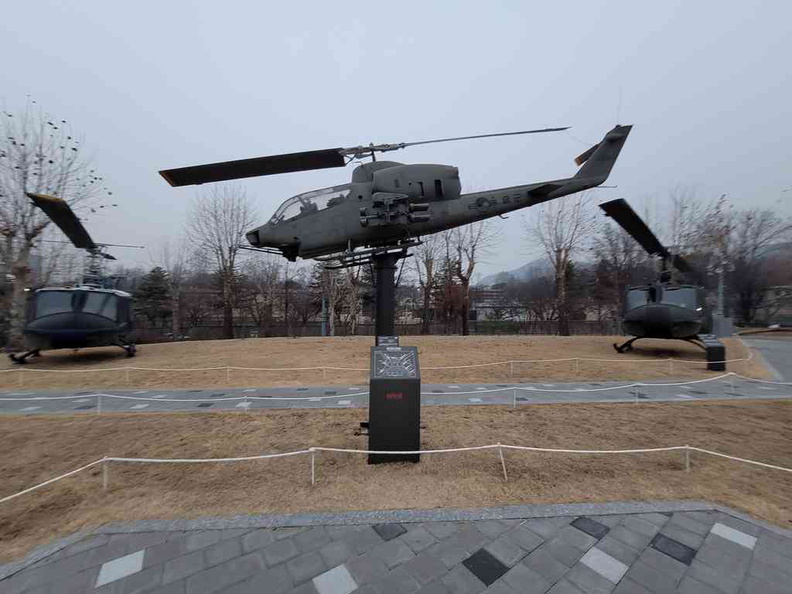 A SuperCobra attack helicopter franked by UH-1 on the outdoor hardware garden