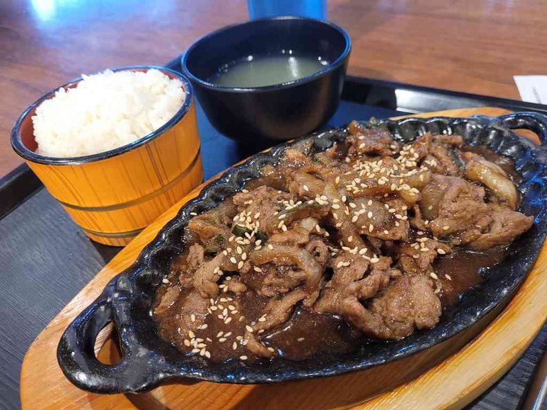 Korean traditional stir fry hotplate beef Bulgogi with sides of rice and soup