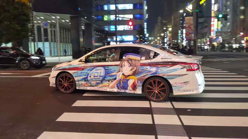 An itasha decorated car making its rounds around Akihabara