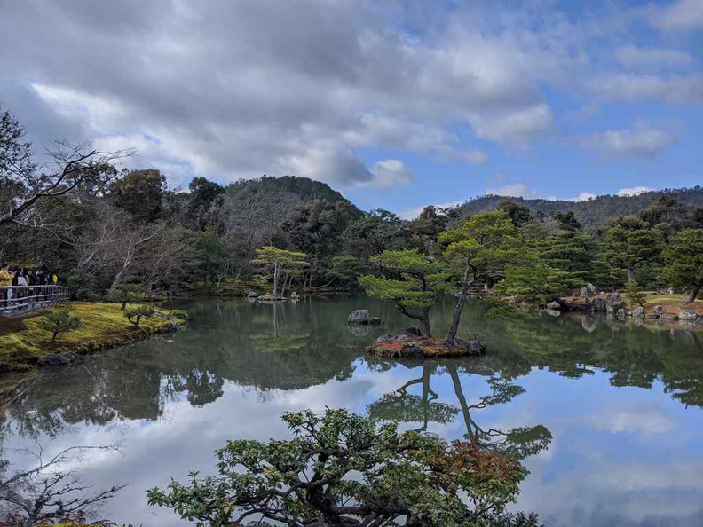Kinkaku-ji Temple reflecting lake with a hilly background