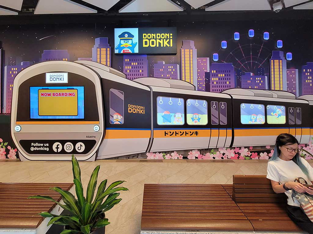 This Donki at Paya lebar quarters has an MRT transport theme, shown by a mural. 