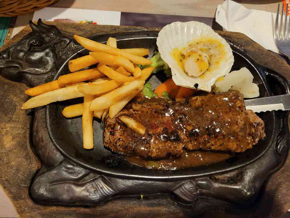 Striplion steak on hotplate with fries and scallops ($27.90)